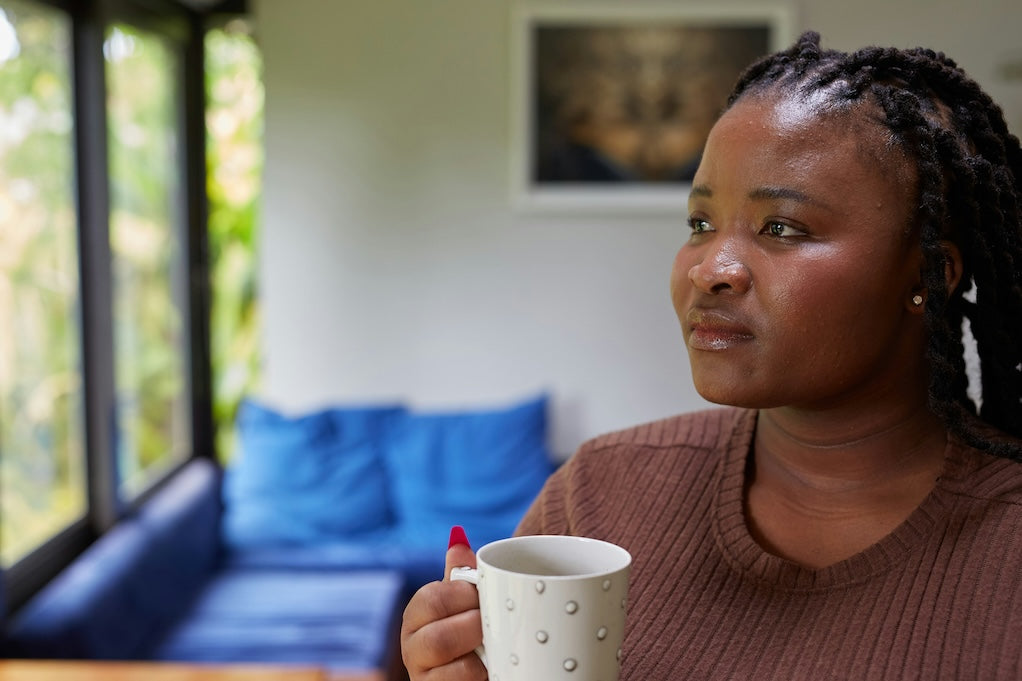 A woman is sitting with a coffee contemplating the daily challenges of managing type 1 diabetes