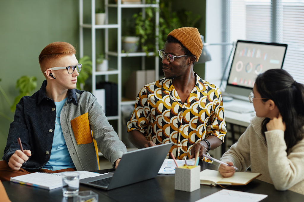 Neurodiversity in the workplace demonstrated by three diverse young employees working together. 