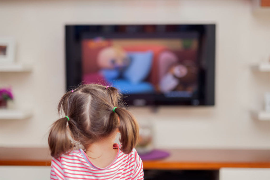 A photo of the rear of a young child's head watching television as a way of overcoming childhood medical trauma.