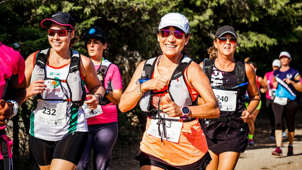 A photo of people running a race while wearing running hydration packs