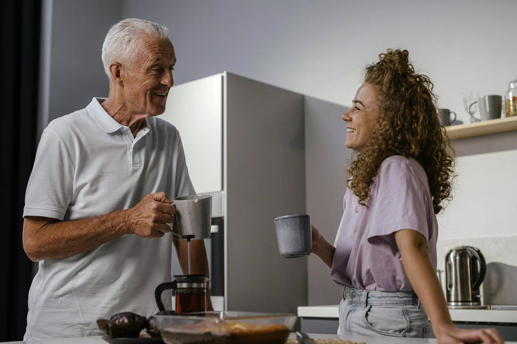 Supporting an elderly relative’s health and independence by supporting them in person. A daughter visits her dad for a coffee and a chat.