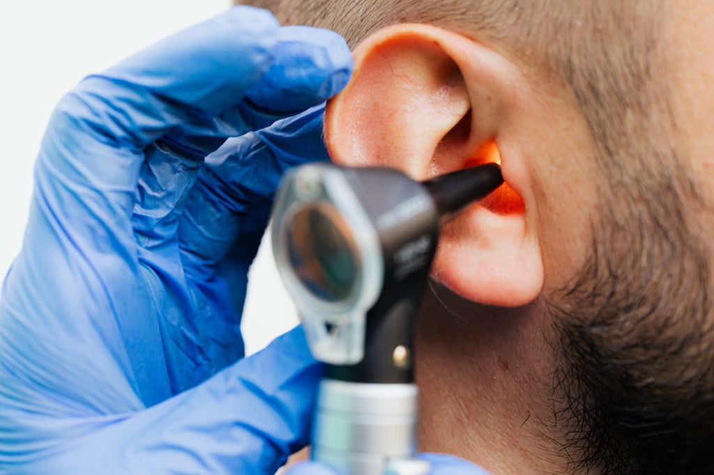 A doctor is looking inside a person's ear