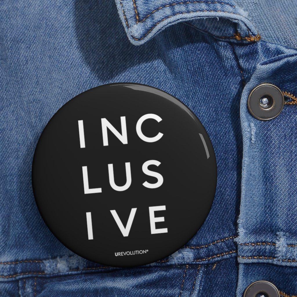 DEI pins - a diversity Inclusion Pin Button is on a denim jacket. The pin button has the word inclusive printed on it in upper case letters. 