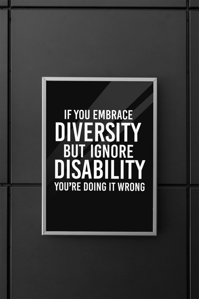 A framed DEI poster with the message 'If you embrace diversity but ignore disability, you're doing it wrong' displayed on a modern black office wall.