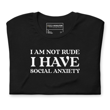 Folded black t-shirt with white text that reads "I Am Not Rude, I Have Social Anxiety." A statement tee for social anxiety awareness