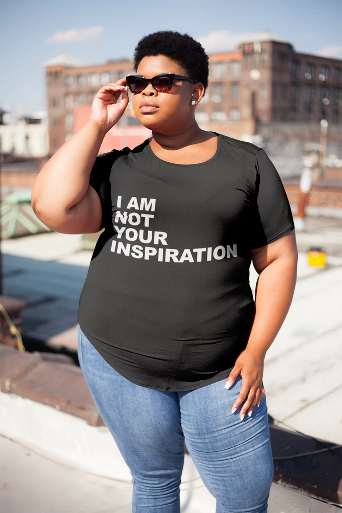 A plus size model is wearing a t-shirt with the phrase, "I am not your inspiration," on it