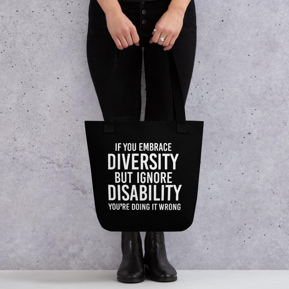 Photo of a black Embrace Diversity Tote with the phrase, "If you embrace diversity, but ignore disability, you're doing it wrong," printed on it in white upper case letters. 